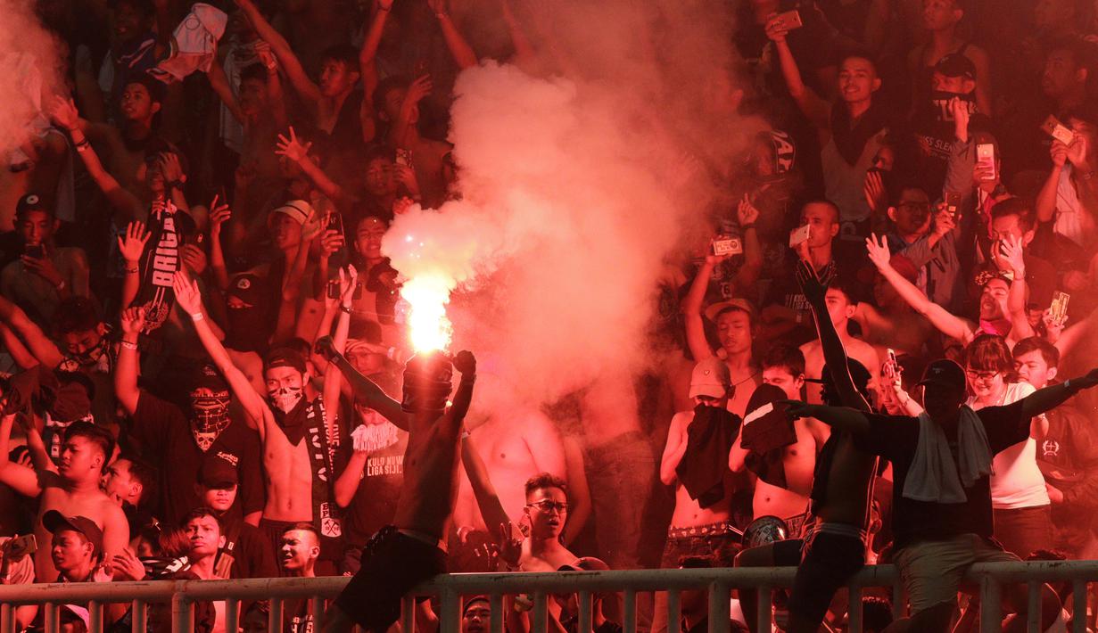 Suporter PSS Sleman menyalakan flare saat melawan Semen Padang pada laga Liga 2 di Stadion Pakansari, Jawa Barat, Selasa (4/12). PSS menang 2-0 atas Semen Padang. (Bola.com/M. Iqbal Ichsan)
