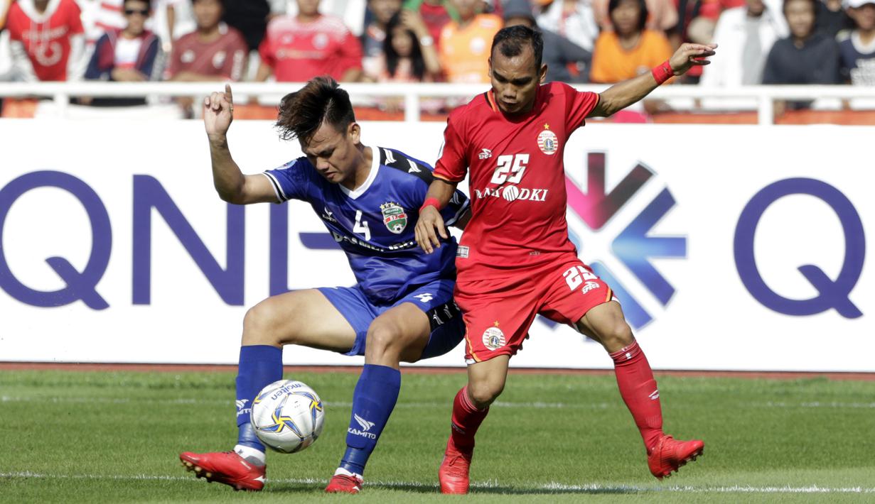 Gelandang Persija Jakarta, Riko Simanjuntak, berebut bola dengan bek Becamex Binh Duong FC, Ho Tan Tai, pada laga Piala AFC di SUGBK, Jakarta, Selasa (26/2). Kedua klub bermain imbang 0-0. (Bola.com/M. Iqbal Ichsan)