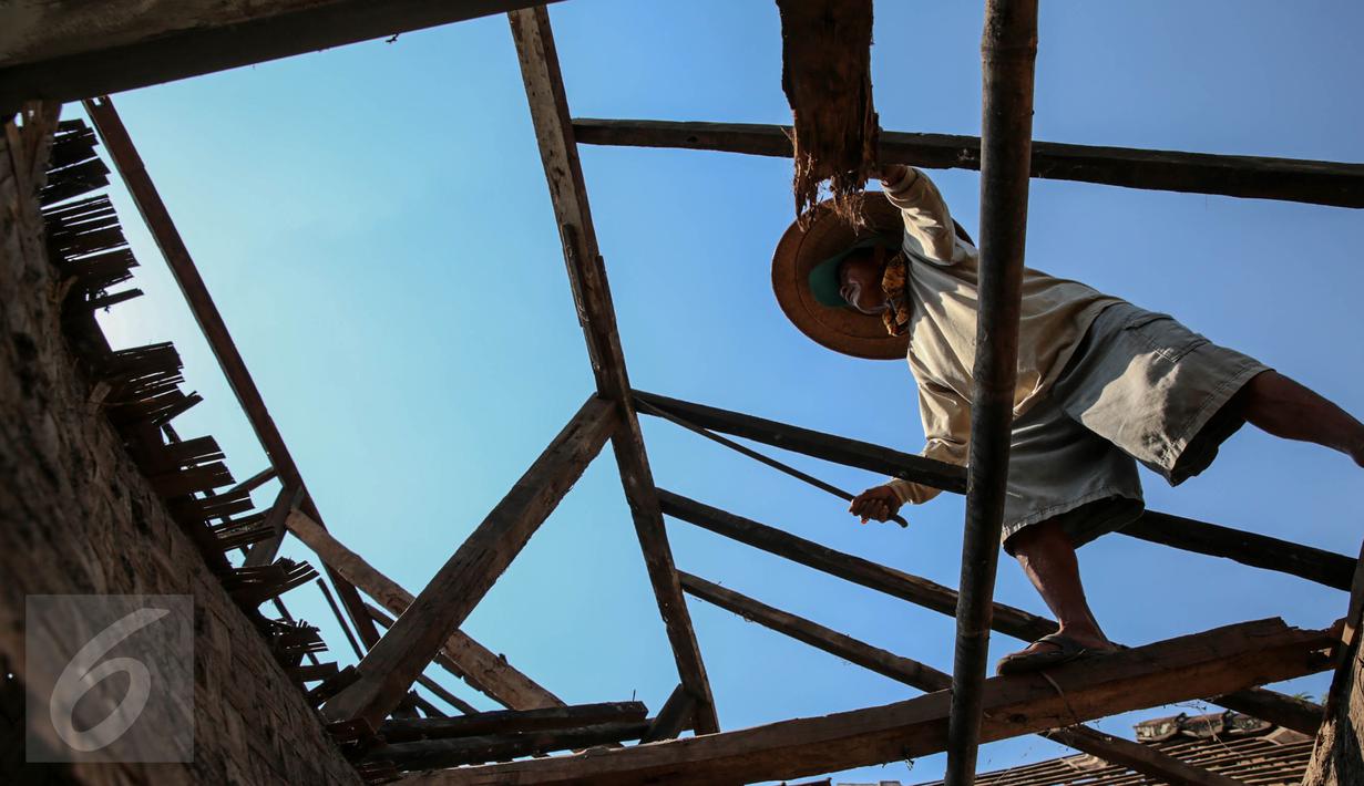 Warga membongkar sendiri rumah yang akan terkena dampak penggenangan Waduk Jatigede di Desa Cipaku, Sumedang, Jawa Barat, Senin (31/8/2015). Beberapa warga masih ada yang bertahan karena belum tuntasnya soal ganti rugi. (Liputan6.com/Faizal Fanani)