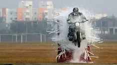 Seorang anggota tentara India dari tim sepeda motor 'Tornado' menabrak lampu selama latihan gabungan di akademi pelatihan perwira di Chennai (9/3). (AFP Photo/Arun Sankar)