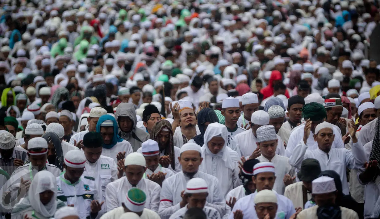 Seorang peserta aksi damai 2 Desember berdoa saat melaksanakan salat Jumat di Monas, Jakarta, Jumat (2/12). Meski hujan mengguyur, massa tetap bertahan di saf masing-masing dan melangsungkan salat Jumat bersama-sama. (Liputan6.com/Faizal Fanani)