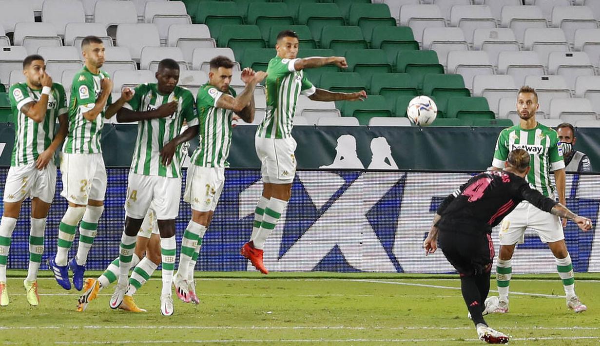 Bek Real Madrid, Sergio Ramos, melepaskan tendangan bebas ke gawang Real Betis pada laga La Liga di Stadion Benito Villamarin, Minggu (27/9/2020). Real Madrid menang dengan skor 3-2. (AP Photo/Angel Fernandez)