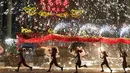 Penari melakukan tarian naga di sebuah taman pada hari keempat Tahun Baru Imlek di Beijing (8/2). China menandai kedatangan Tahun Babi dengan liburan Festival Musim Semi selama seminggu.  (AFP Photo/Greg Baker)