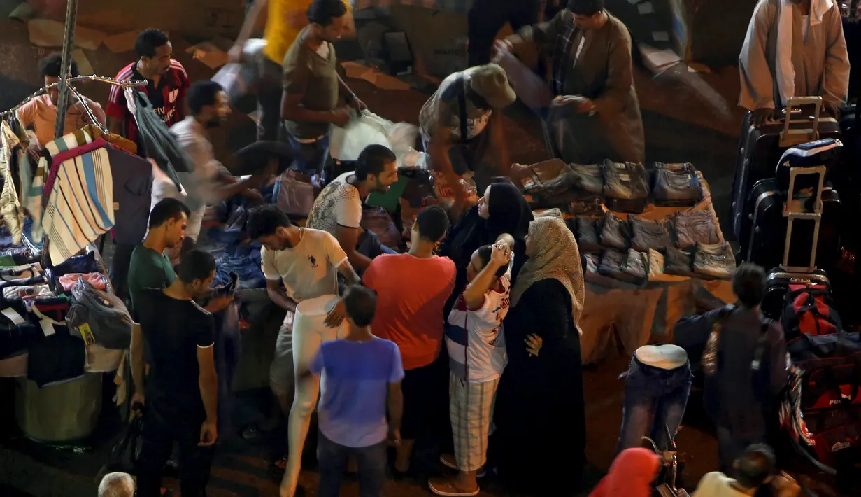 Warga memilih barang saat berbelanja di Al Ataba, pasar yang populer di pusat kota Kairo, Mesir, Rabu (15/7/2015). Muslim di seluruh dunia sedang mempersiapkan untuk menyambut datangnya Hari Raya Idul Fitri. (REUTERS/Mohamed Abd El Ghany)