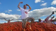 Peserta berdiri di atas gundukan tomat saat Festival Tomatina di Sutamarchan, Boyaca, Kolombia, Minggu (2/6/2019). Perang tomat ini digelar selama tiga hari berturut-turut. (Diana SANCHEZ/AFP)