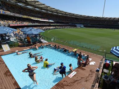 Sejumlah penonton berada di kolam renang menyaksikan pertandingan uji coba kriket antara Australia dan Pakistan di dalam stadion Gabba di Brisbane, Australia (15/12). (AFP Photo/Saeed Khan)