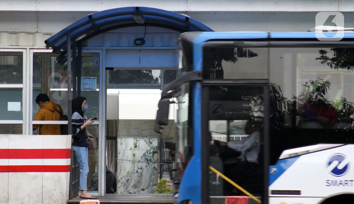 Pengguna bus Transjakarta menggunakan masker di halte kawasan Kuningan, Jakarta, Rabu (27/5/2020). Empat provinsi di Indonesia termasuk DKI Jakarta akan mulai melakukan persiapan menuju new normal atau tatanan kehidupan baru menghadapi COVID-19. (Liputan6.com/Helmi Fithriansyah)