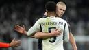 Striker Manchester City, Erling Haaland memeluk gelandang Real Madrid, Jude Bellingham setelah berakhirnya laga leg pertama babak perempatfinal Liga Champions 2023/2024 yang berakhir imbang 3-3 di Santiago Bernabeu Stadium, Selasa (9/4/2024) malam. (AP Photo/Manu Fernandez)