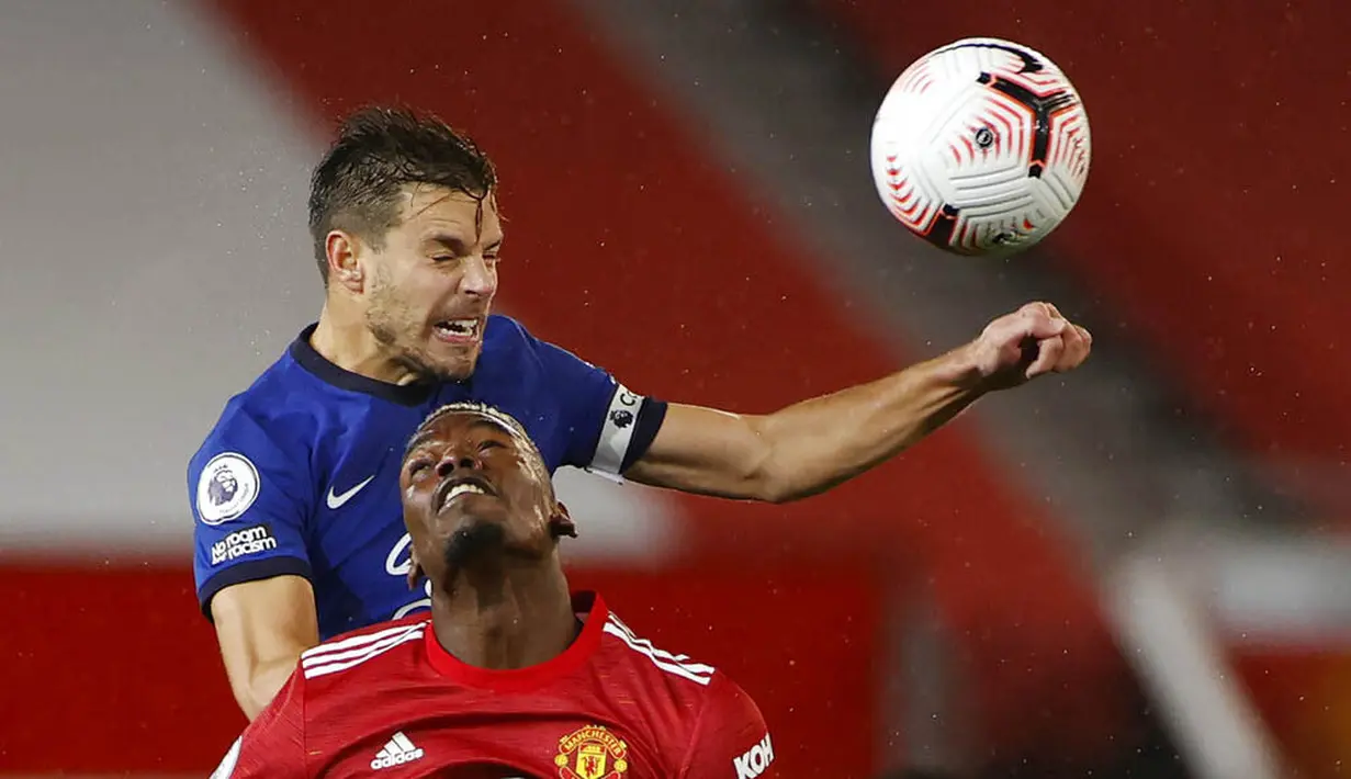 Gelandang Manchester United, Paul Pogba, duel udara dengan bek Chelsea, Cesar Azpilicueta, pada laga Liga Inggris di Stadion Old Trafford, Minggu (25/10/2020). Kedua tim bermain imbang 0-0. (Phil Noble/Pool via AP)