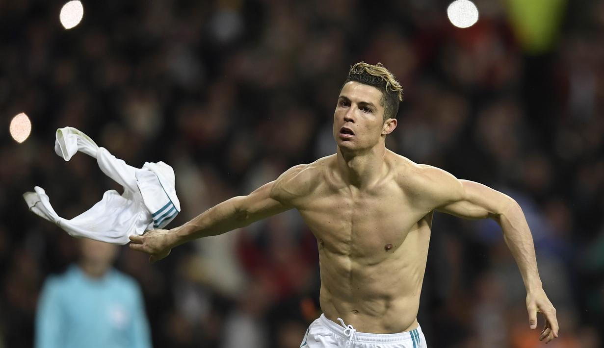 Striker Real Madrid, Cristiano Ronaldo, melepas baju untuk melakukan selebrasi usai mencetak gol ke gawang Juventus pada laga Liga Champions di Stadion Santiago Bernabeu, Rabu (11/4/2018). (AFP/Oscar Del Pozo)