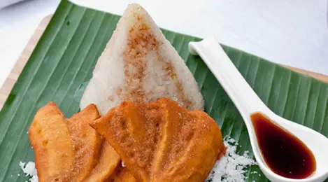 Ketan Pisang Tradisional: Ketan Pisang kukus yang dibungkus daun pisang, menciptakan aroma khas dan rasa manis gurih