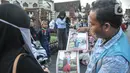 Fotografer keliling menawarkan jasanya kepada peziarah Makam Sunan Kudus, Kauman, Kabupaten Kudus, Jawa Tengah, Rabu (30/3/2022). Arka (45) anggota Paguyuban Fotografer Menara Kudus mengaku pendapatan dari jasa foto peziarah meningkat menjelang bulan Ramadan. (merdeka.com/Iqbal S. Nugroho)