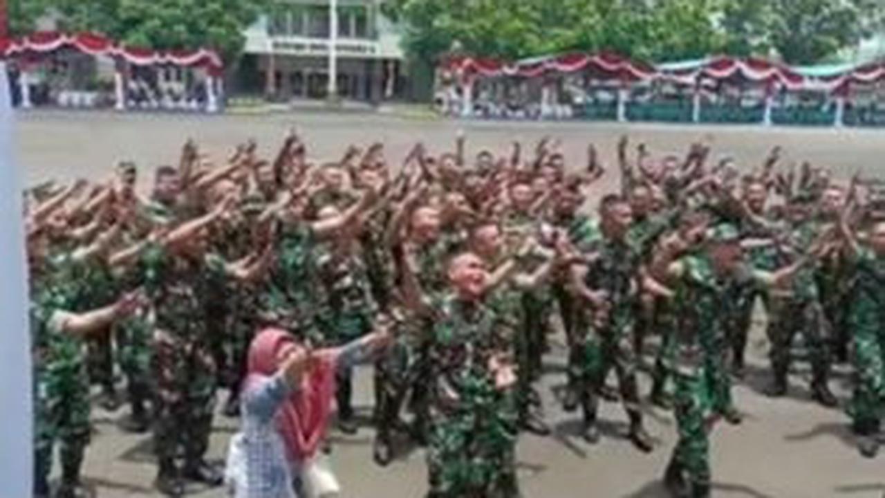 Dalam video, wanita berpakaian biru dan kerudung merah muda itu tampak asyik ikut berjoget dengan beberapa prajurit TNI.