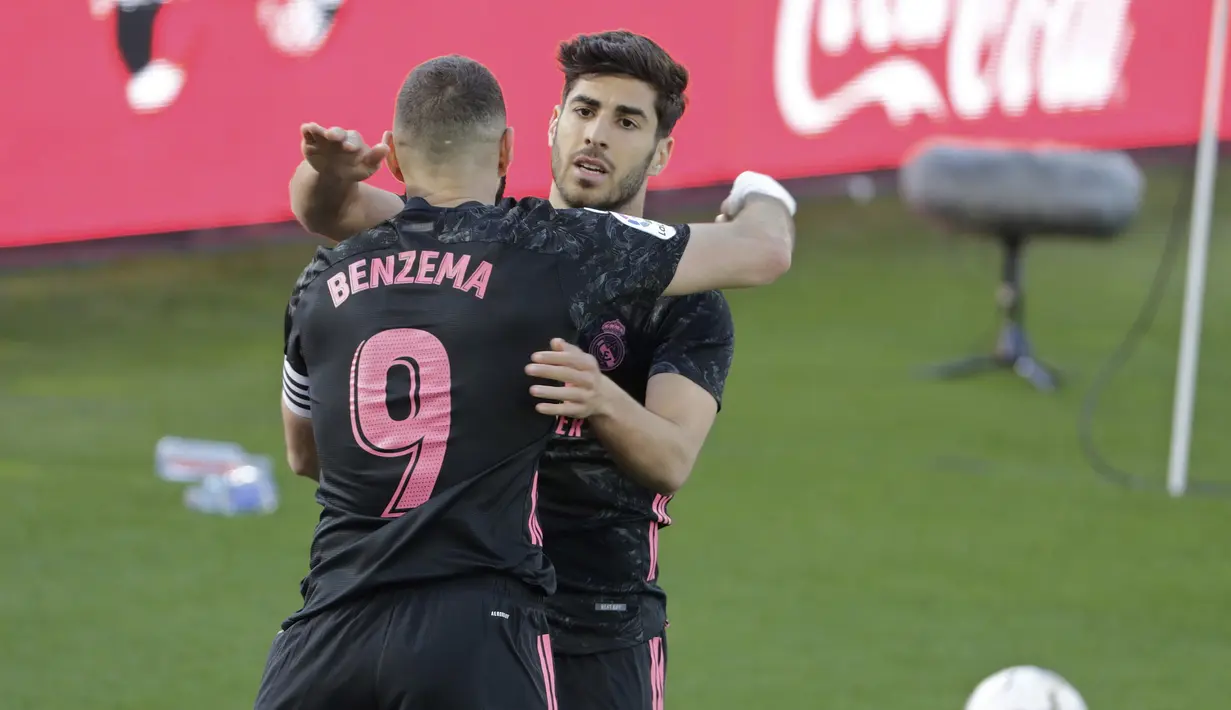 Gelandang Real Madrid, Marco Asensio (kanan) melakukan selebrasi bersama Karim Benzema usai mencetak gol ketiga timnya ke gawang Celta Vigo dalam laga lanjutan Liga Spanyol 2020/2021 pekan ke-28 di Balaidos Stadium, Sabtu (20/3/2021). Real Madrid menang 3-1 atas Celta Vigo. (AP/Lalo R. Villar)