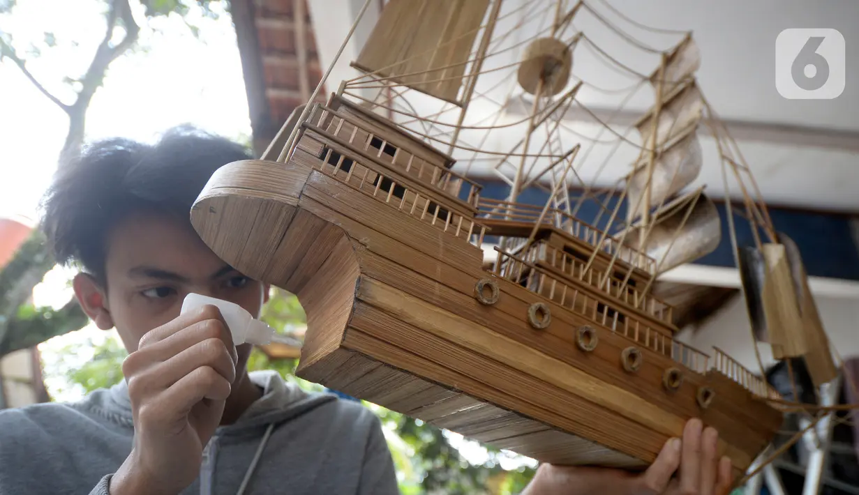 Perajin menyelesaikan pembuatan miniatur kapal pinisi yang terbuat dari limbah bambu di Pondok Benda, Pamulang, Tangerang Selatan, Senin (09/11/2020). Kerajinan berbahan bambu bekas yang dijual dengan harga berkisar Rp.50 ribu hingga Rp.250 ribu tergantung ukurannya. (merdeka.com/Dwi Narwoko)