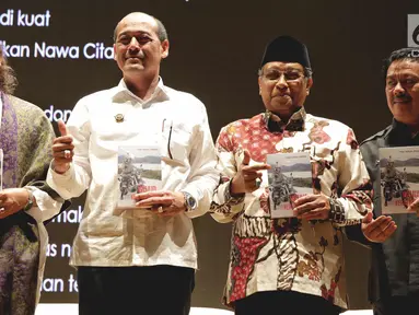 Ketua Umum Nawacita Jokowi, Mas Raden Suryo Admanto (kedua kiri) berfoto bersama Ketua Umum PBNU Said Aqil Siradj (kedua kanan) saat peluncuran buku tiga tahun Jokowi di Perpustakaan Nasional, Jakarta, Senin (6/11). (Liputan6.com/Faizal Fanani)