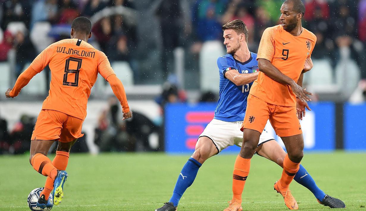 Pemain Italia, Daniele Rugani (tengah) berusaha menutup pergerakan pemain Belanda, Georginio Wijnaldum (kiri) pada laga uji coba di Allianz Stadium, Turin, (4/6/2018). Italia dan Belanda bermain imbang 1-1. (Alessandro Di Marco/ANSA via AP)