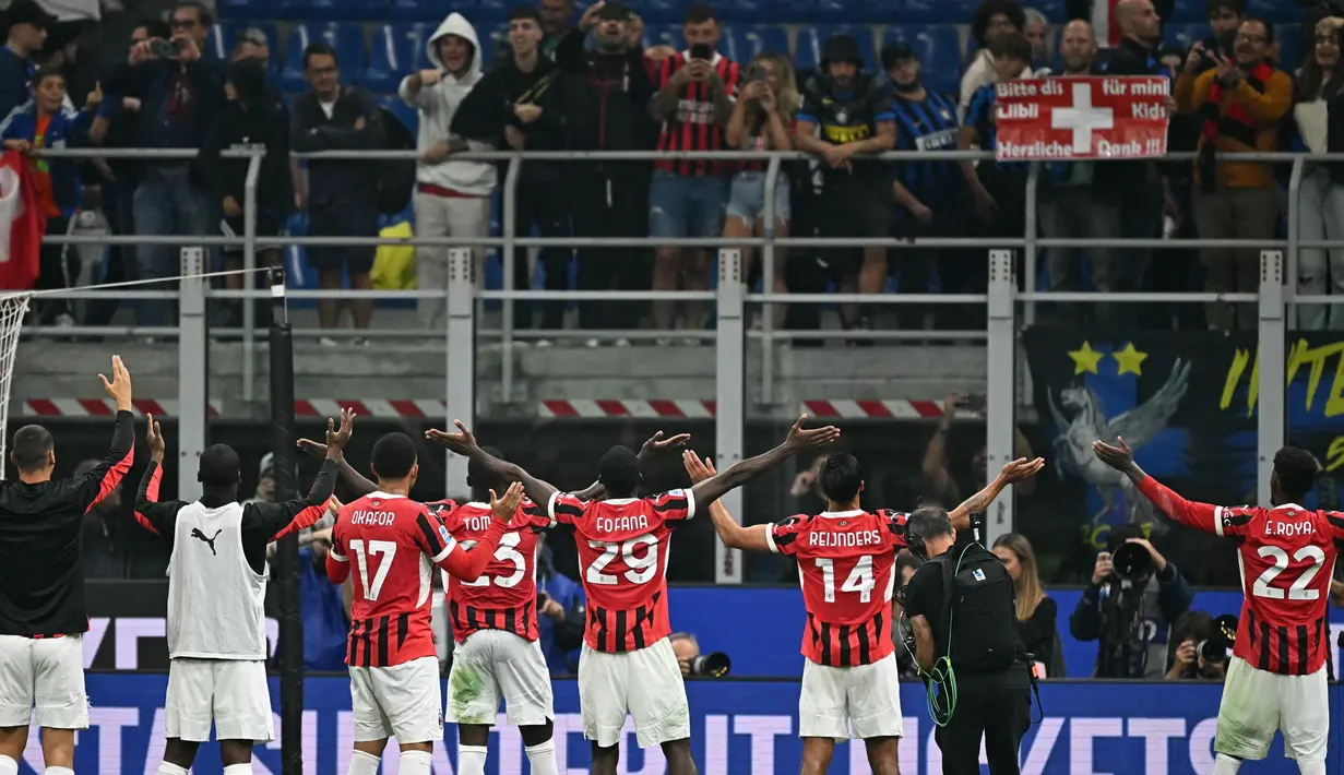 Para pemain AC Milan menyapa para penggemar usai memenangi laga Serie A Italia melawan Inter Milan di stadion Giuseppe Meazza, Milan, pada Minggu 22 September 2024 atau Senin (23/9/2024) dini hari WIB. (Gabriel BOUYS/AFP)