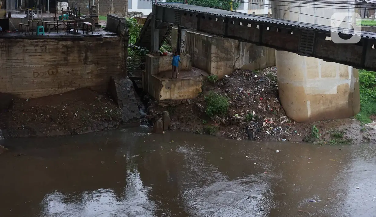 Seorang pria memancing di pinggir aliran Sungai Ciliwung kawasan Rawajati, Jakarta, Selasa (17/12/2019). Hujan deras yang mengguyur Jakarta sejak siang menyebabkan debit air Sungai Ciliwung mulai mengalami kenaikan, namun masih terpantau normal. (Liputan6.com/Immanuel Antonius)