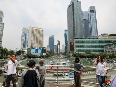 Sejumlah warga berswafoto di tengah polusi di anjungan Halte Transjakarta, kawasan Bundaran Hotel Indonesia (HI), Jakarta, Sabtu (23/9/2023). (Liputan6.com/Faizal Fanani)