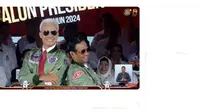 Ketika masuk ke dalam panggung debat capres, paslon nomor urut 3 Ganjar Pranowo-Mahfud Md cukup menarik perhatian. Sebab, keduanya menggunakan jaket bomber berwarna hijau dan kacamata hitam. (YouTube KPU RI)
