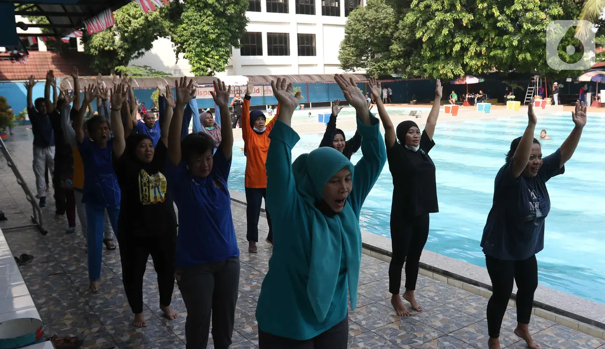 Sejumlah peserta melakukan pemanasan saat berlatih berenang pada kegiatan Gerakan Prolanis Total (Gelato) di Gelanggang Remaja KONI, Gambir, Jakarta, Kamis (11/8/2022). Puskesmas Kecamatan Gambir mengadakan kegiatan Gelato berupa pelatihan berenang kepada peserta lansia penderita penyakit kronis untuk mencegah penyakit tersebut tambah parah. (Liputan6.com/Herman Zakharia)
