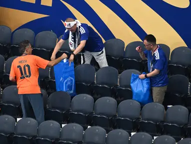 Aksi terpuji suporter Jepang yang selalu membersihkan sampah di tribun seusai pertandingan telah menjadi tradisi ikonik yang mendunia. (AP Photo/Jessica Tobias)