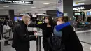 Anggota keluarga saling berpelukan ketika mereka bertemu kembali setelah terbang dari Amsterdam di Dulles International Bandara, Virginia, Senin (8/11/2021). AS membuka kembali perbatasannya mulai Senin untuk pengunjung asing, mengakhiri larangan masuk selama 20 bulan. (Olivier DOULIERY/AFP)