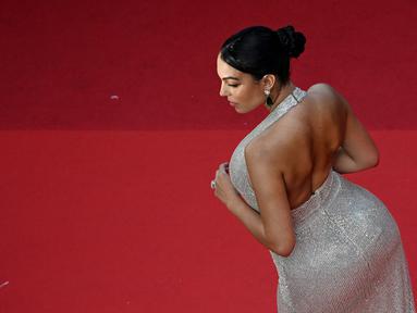 Pasangan Cristiano Ronaldo, Georgina Rodriguez tiba untuk pemutaran film "Elvis" selama Festival Film Cannes edisi ke-75 di Cannes, Prancis selatan, pada 25 Mei 2022. Georgina Rodriguez tampil menawan dalam balutan gaun berpayet perak dengan garis leher halter yang menjuntai dan belahan setinggi paha. (PATRICIA DE MELO MOREIRA / AFP)