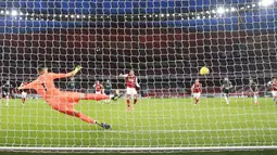 Pemain Arsenal Pierre-Emerick Aubameyang (tengah) mencetak gol dari titik penalti ke gawang Leeds United pada pertandingan Liga Inggris di Emirates Stadium, London, Inggris, Minggu (14/2/2021). Arsenal menyikat Leeds United 4-2 dengan hattrick dari Pierre-Emerick Aubameyang. (Adam Davy/Pool via AP)