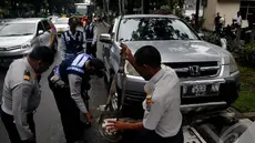 Petugas Dishub saat mengangkut mobil yang parkir sembarangan, Jakarta, Senin (12/1/2015). (Liputan6.com/Johan Tallo)
