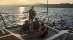 Keempat sahabat ini menaiki kapal sambal menikmati sunset di tengah laut. (Liputan6.com/Twitter/@BTS_twt)