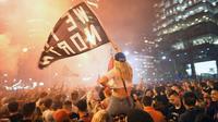 Warga Kanada berpesta turun ke jalan-jalan merayakan keberhasilan Toronto Raptors menjuarai NBA 2018-2019, Jumat (14/6/2019). (AFP/Geoff Robbins)