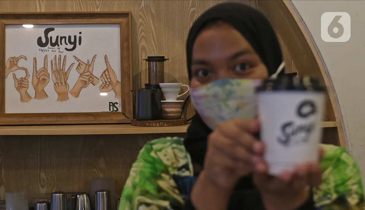 Barista menunjukkan kopi buatannya di Sunyi House of Coffee and Hope, Jakarta, Jumat (15/1/2021). Rumah kopi ini mempekerjakan difabel untuk melayani pengunjung dan mengajari bahasa isyarat alfabet. (Liputan6.com/Herman Zakharia)