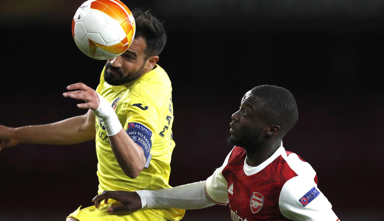 Bek Villarreal, Mario Gaspar (kiri) berebut bola dengan gelandang Arsenal, Nicolas Pepe dalam laga leg kedua semifinal Liga Europa 2020/2021 di Emirates Stadium, London, Kamis (6/5/2021). Villarreal bermain imbang 0-0 dengan Arsenal. (AP/Alastair Grant)