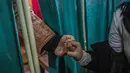 Remaja Kashmir memegang tangan kerabatnya saat bersiap divaksin COVID-19 di sebuah sekolah di Srinagar, Senin (3/1/2022). India mulai memvaksinasi remaja 15-18 tahun saat banyak negara bagian memberlakukan pembatasan ketat untuk menahan lonjakan kasus omicron. (AP Photo/Mukhtar Khan)