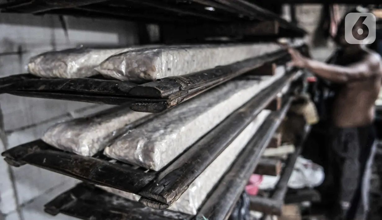 Perajin memproduksi tempe di kawasan Sunter, Jakarta, Senin (4/1/2021). Perajin tempe setempat berupaya mengurangi kerugian akibat melonjaknya harga kedelai impor dengan memperkecil ukuran tempe dan menaikan harga jual kisaran Rp1.000 - Rp2.000 per potong. (merdeka.com/Iqbal S. Nugroho)