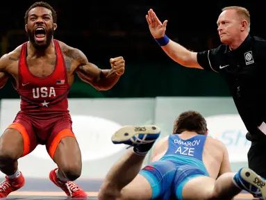 Burroughs Jordan dari AS (kiri) merayakan kemenangan usai mengalahkan Gasjimurad Omarov dari Azerbaijan dalam pertandingan gulat 74 kilogram di Freestyle Wrestling World Cup di Iowa City, Iowa (8/4). (AP Photo/Charlie Neibergall)