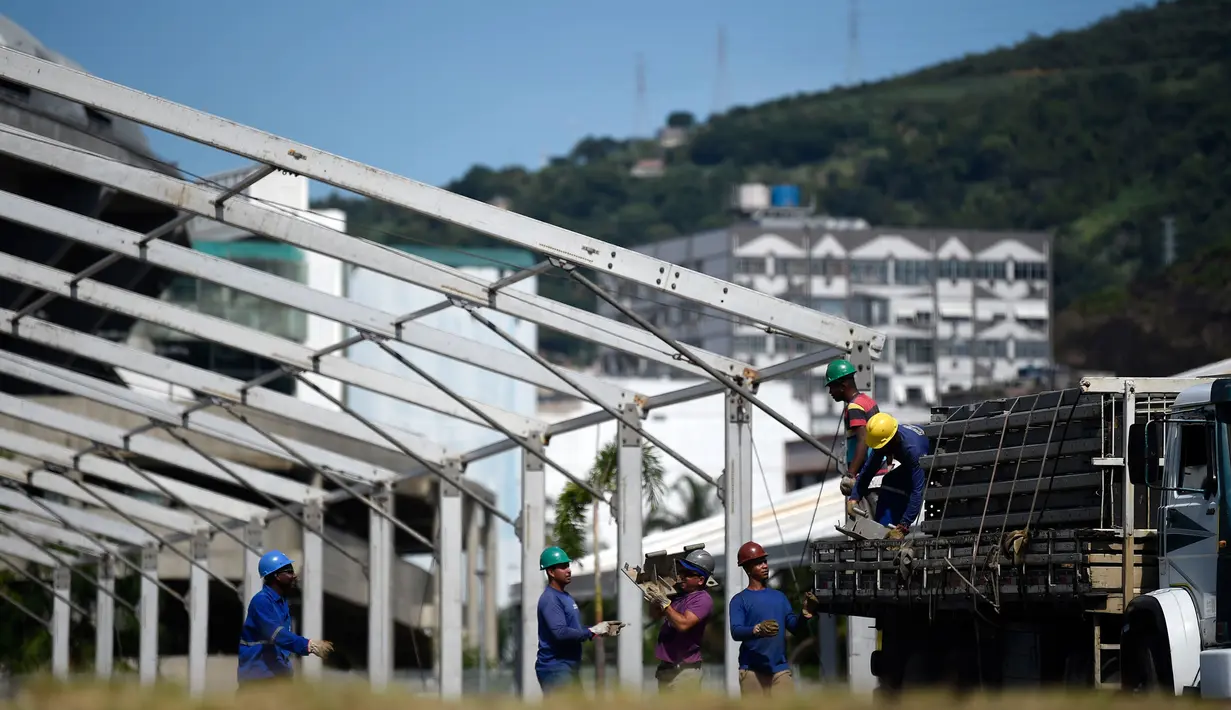 Pekerja memulai pembangunan rumah sakit darurat bagi pasien terinfeksi Covid-19 di kompleks stadion Maracana, Rio de Janeiro, Kamis (2/4/2020). Sebagian kompleks stadion paling terkenal di Brasil itu diubah menjadi rumah sakit lapangan selama pandemi Covid-19. (MAURO PIMENTEL/AFP)