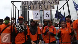 Sejumlah buruh membawa kerangkeng saat aksi May Day 2016 di Jakarta, Minggu (1/5). Kaum buruh mengajukan tuntutan menolak upah murah serta pencabutan PP No. 78 Tahun 2015. (Liputan6.com/Angga Yuniar)