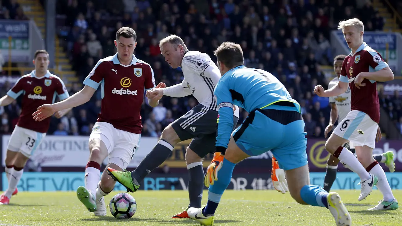 Striker Manchester United (MU) Wayne Rooney melepas tembakan untuk merobek gawang Burnley di Turf Moor, Minggu (23/4/2017). MU menang 2-0.