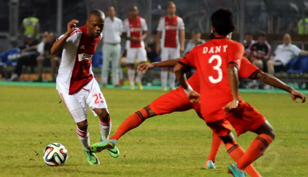 Thulani Serero (Ajax Amsterdam-kiri) mencoba menghindari dari tackling pemain Persija saat berlaga di Stadion GBK Jakarta, (11/5/2014). (Liputan6.com/Helmi Fithriansyah)