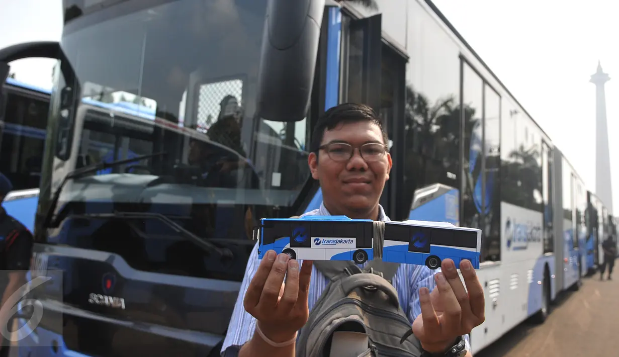 Warga memperlihatkan miniatur Bus transjakarta bermerek Scania saat acara peluncuran di Silang monas, Jakarta, Senin (22/6/2015). Ada sebanyak 20 unit bus transjakarta bermerek Scania yang diluncurkan pertengahan Juni ini. (Liputan6.com/Herman Zakharia)