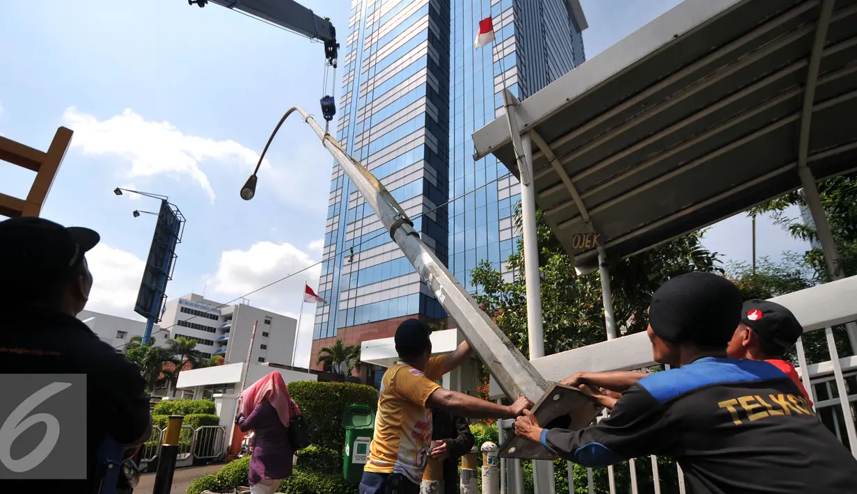 Pekerja mencopot lampu dan mengganti tiang lampu PJU di Jakarta, Selasa (29/12). Pemrov DKI Jakarta akan mengganti seluruh lampu listrik Penerangan Jalan Umum (PJU) dari konvensional menjadi lampu hemat energi LED. (Liputan6.com/Yoppy Renato)