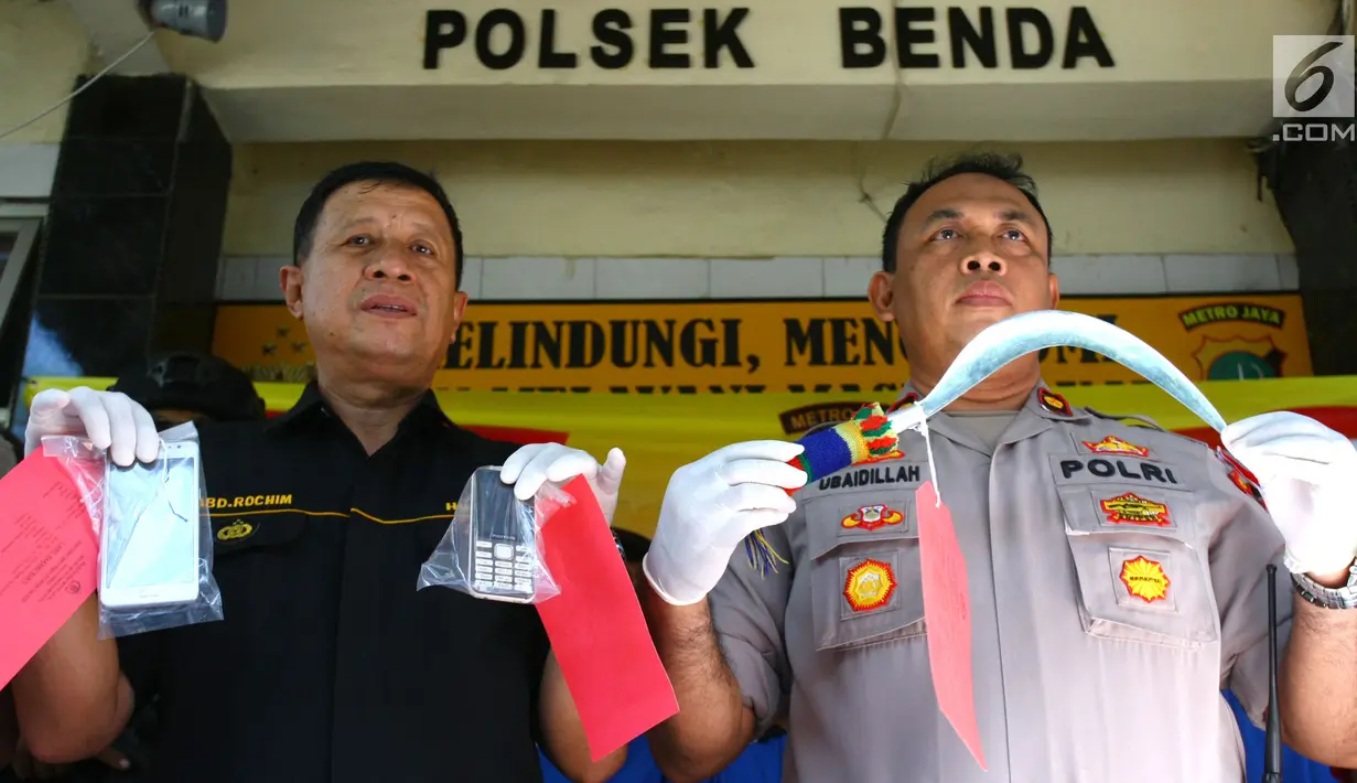 Polisi menunjukkan barang bukti celurit dan handphone di Mapolsek Benda, Tangerang, Banten, Senin (19/11). Polisi menangkap otak pelaku kejahatan spesialis handphone dan tiga tersangka lainnya. (Liputan6.com/Fery Pradolo)