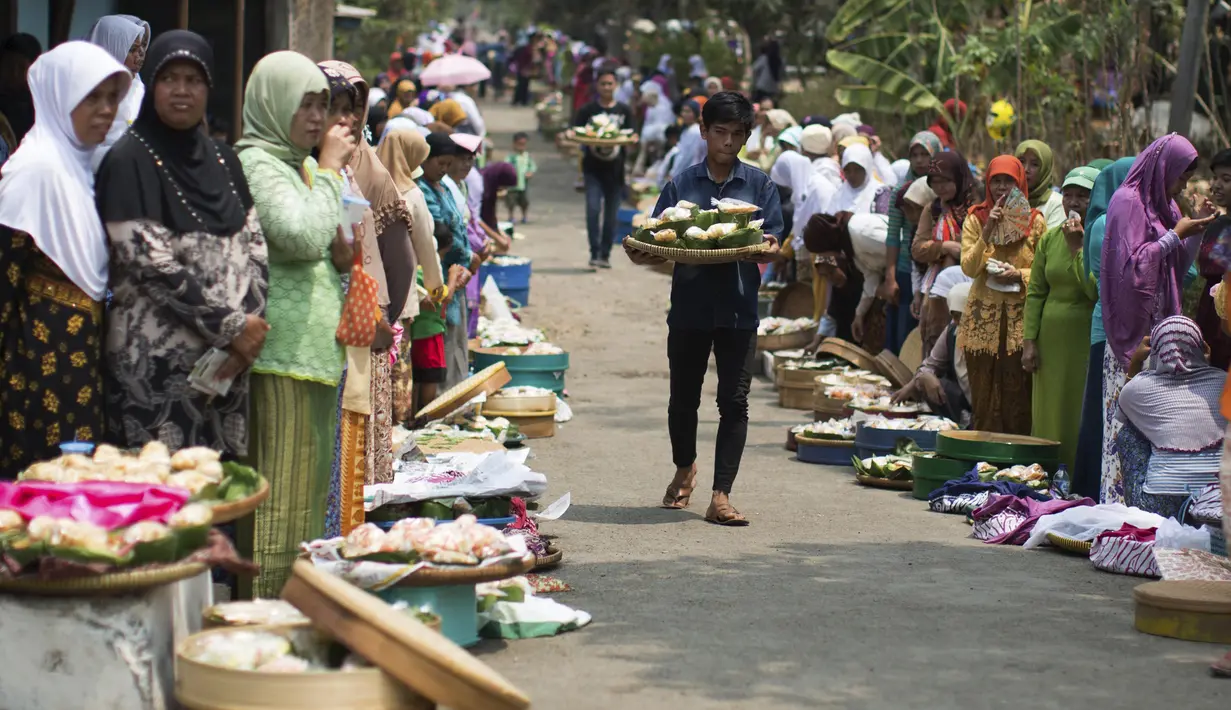 Warga berdiri di dekat makanan dan hasil pertanian jelang ritual sedekah bumi di Desa Karang Jati, Banjarnegara, Jateng, Jumat (23/10). Ini bentuk penghormatan terhadap Tuhan dan alam agar terhindar dari kemarau berkepanjangan. (REUTERS/Nicholas Owen)