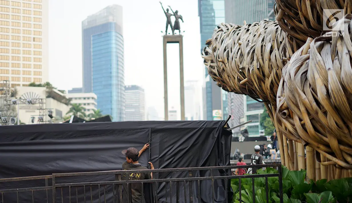 Pekerja menyelesaikan pembuatan panggung hiburan malam puncak HUT Ke-492 Kota Jakarta di Bundaran HI, Jakarta, Jumat (21/6/2019).Rangkaian malam puncak HUT Jakarta diisi dengan live mural, bazar kreatif dan donasi, video mapping hingga festival musik. (Liputan6.com/Immanuel Antonius)