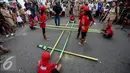 Sejumlah murid sekolah dasar bermain permain daerah dalam festival permainan tradisional rakyat Maluku didepan Balai Kota Ambon, Maluku, Selasa (7/2). Festival tersebut diselenggarakan untuk memperingati Hari Pers Nasional. (Liputan6.com/Faizal Fanani)