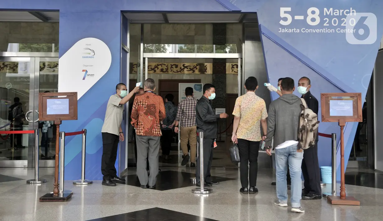 Petugas memeriksa suhu tubuh pengunjung GAIKINDO Indonesia International Commercial Vehicle Expo (GIICOMVEC) 2020 di JCC, Senayan, Jakarta, Kamis (5/3/2020). Pihak GIICOMVEC juga menyediakan ruang medis untuk mengantisipasi penyebaran virus corona (COVID-19). (merdeka.com/Iqbal Nugroho)