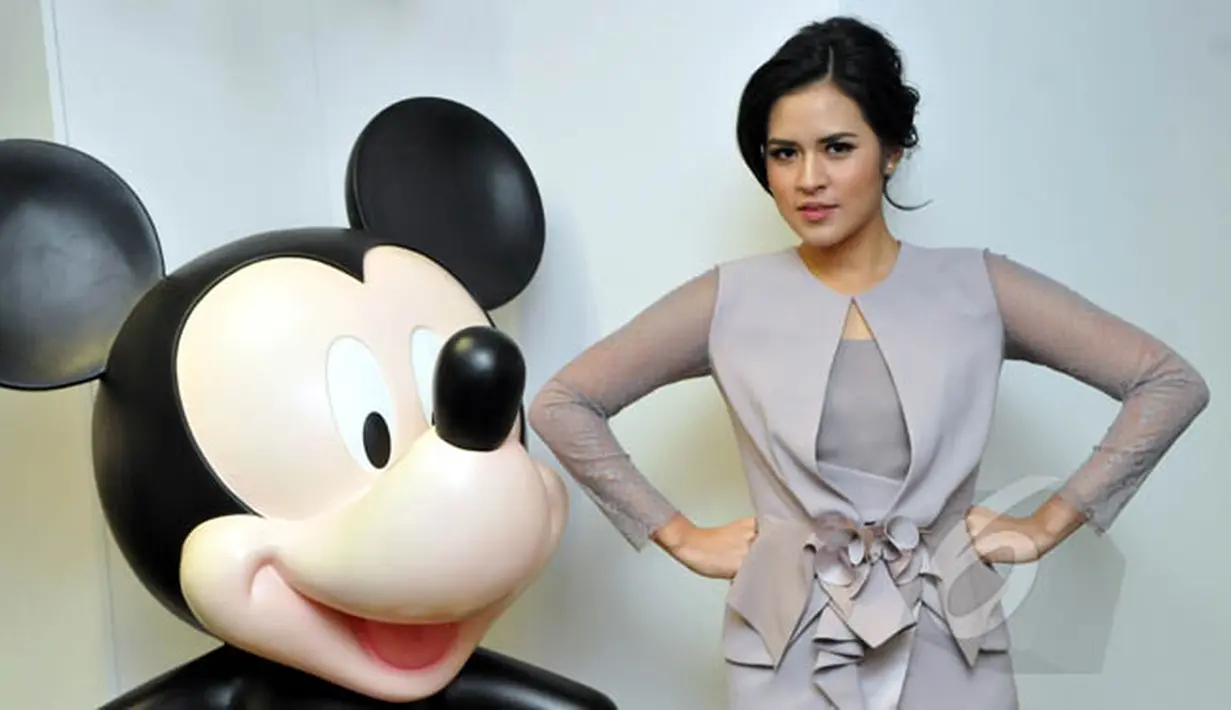 Penyanyi cantik, Raisa berpose dengan patung mickey mouse saat ditemui di kantor PT Walt Disney Indonesia, Jakarta, Rabu (18/2/2015). (Liputan6.com/Panji Diksana)